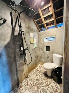 a bathroom with a shower and a toilet at Sawit House by Natural View in Karangasem