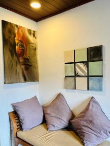 a couch in a room with a painting on the wall at Sawit House by Natural View in Karangasem