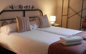 two beds in a room with two white beds at El Rincon 53 in Quintanilla del Monte