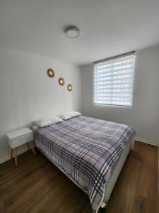 a white bedroom with a bed and a window at Céntrico y cómodo departamento in Los Andes
