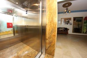 a glass shower in a room with a couch at Willa ROZA in Łeba +52 photos