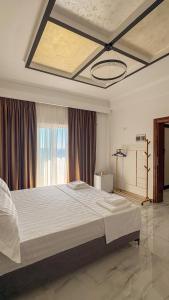 a bedroom with a large bed with a large window at Thea Rooms in Himare