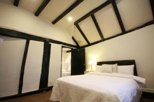 um quarto com uma cama branca num quarto em Crown Hotel em Nantwich