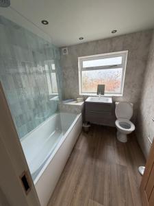 a bathroom with a tub and a toilet and a sink at The Blue Bell Inn in Amble