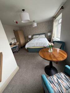 a bedroom with a bed and a table and a table at The Blue Bell Inn in Amble