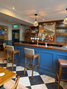 a bar in a restaurant with chairs and tables at The Blue Bell Inn in Amble