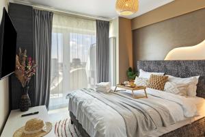 a bedroom with a large bed and a large window at Chocolat in Odyssey Pool & Spa Resort in Mamaia Sat/Năvodari