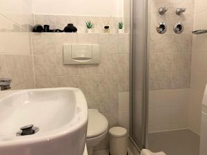 a bathroom with a white sink and a toilet at Seeuferresidenz am Adrian Stoop NEU eingerichtet in Bad Wiessee