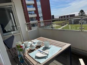 a table on a balcony with a view of a building at Wellenkieker in Wyk auf Föhr