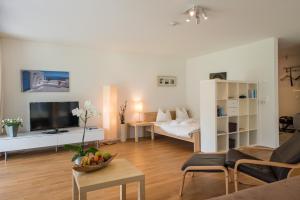 ein Wohnzimmer mit einem Sofa und einem TV in einem Zimmer in der Unterkunft Edelweiss Uletsch S 0.2 in Laax