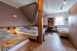 a bedroom with three beds and a table and chairs at KARCZMA-KOSZWICE in Koszwice +78 photos