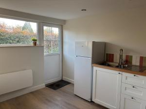 a kitchen with a white refrigerator and a window at Maison rénovée - 2 chambres - 4 pers - L'Abeel Escapade in Bailleul