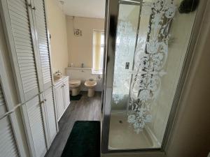 a bathroom with a shower with a glass door at Cozy Private Spacious Blackout Room in Longley
