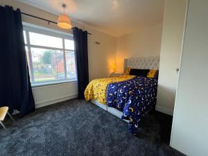 a bedroom with a bed with a comforter and a window at Cozy Private Spacious Blackout Room in Longley