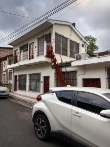 a white car parked in front of a white house at Zacatecoluca House 2 in Zacatecoluca