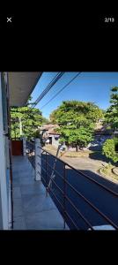 a balcony of a building with a railing and trees at Zacatecoluca House 2 in Zacatecoluca