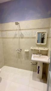 a bathroom with a sink and a shower with a mirror at Hotel Sereena residence in Multan +34 photos