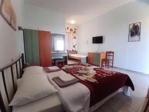 a bedroom with a large bed and a desk at Panorama Rooms in Kyllini