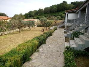 a stone path next to a house with a balcony at Panorama Rooms in Kyllini