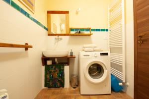 a bathroom with a washing machine and a sink at Romantic stone farmhouse studios with private terrace in beautiful Tuscany in Subbiano