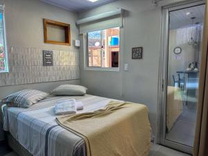 a bedroom with a bed and a glass shower at Bella Mar Suítes in Angra dos Reis