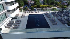 a swimming pool on top of a building with lounge chairs at Chocolat in Odyssey Pool & Spa Resort in Mamaia Sat/Năvodari