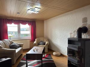 a living room with a couch and a table at Peaceful Forest Getaway in Altenfeld