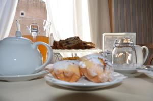 einen Tisch mit Donuts und einer Teekanne in der Unterkunft B&B Porta Baresana in Bitonto