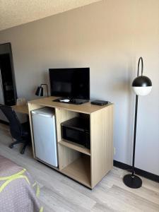 a wooden entertainment center with a flat screen tv at Super 8 by Wyndham Burlington in Burlington