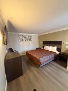a hotel room with a bed and a desk at Colony Inn in Buena Park +20 photos