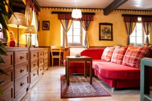 a living room with a red couch and a table at Apartments Belopeški Dvori in Kranjska Gora