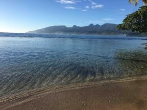a body of water with mountains in the background at Tahiti Sunrise Beach in Vaitoare