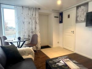 a living room with a couch and a table and a window at Sollidsvägen 1 F in Bro