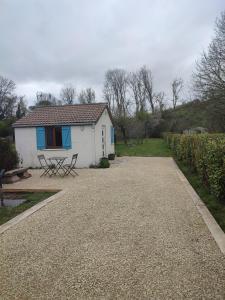 a white house with a picnic table and a bench at Le 13 au vert in Montigny-les-Monts