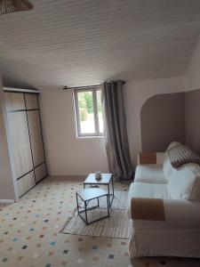 a living room with a white couch and a table at Le 13 au vert in Montigny-les-Monts +5 photos