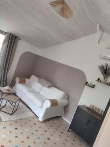 a bedroom with a white bed and a table at Le 13 au vert in Montigny-les-Monts