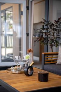 a table with wine glasses and a clock on it at AC Ivona - Mobile home AURORA Vodice in Vodice