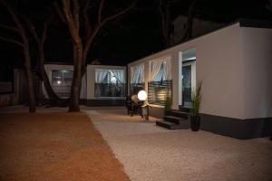 a building with a table and a lamp in front of it at AC Ivona - Mobile home AURORA Vodice in Vodice