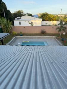 a metal roof with a pool in a backyard at La jolie Villa in Le Lamentin