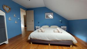 a bedroom with a large bed with blue walls at Les 3 conserveries in Le Crotoy