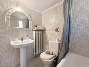a bathroom with a sink and a toilet and a mirror at Elena's 3BR Maisonette with Garden & Pool in Nea Plagia +40 photos