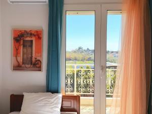a bedroom with a door open to a balcony at Elena's 3BR Maisonette with Garden & Pool in Nea Plagia