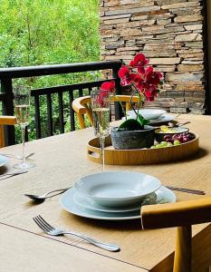 a table with plates and glasses on a wooden table at 320 Zimbali Suites in Ballito