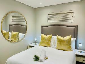 a bedroom with a large bed with a large mirror at 320 Zimbali Suites in Ballito +4 photos