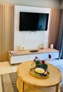 a living room with a table with a tv on the wall at 320 Zimbali Suites in Ballito