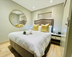 a bedroom with a large bed with a large mirror at 320 Zimbali Suites in Ballito