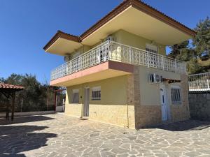a house with a balcony on top of it at Elena's 3BR Maisonette with Garden & Pool in Nea Plagia