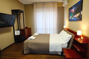 a hotel room with a bed and a flat screen tv at Bergamoincity in Bergamo