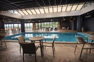 a swimming pool with tables and chairs and a table and a tablektopktopktop at Swan Novo Hamburgo in Novo Hamburgo