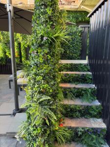 a staircase covered in ivy with flowers and plants at Nuit D Or LoveRoom in Bellegarde-sur-Valserine